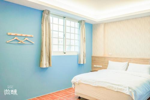 金城金门微醺民宿的一间卧室设有一张床和蓝色的墙壁
