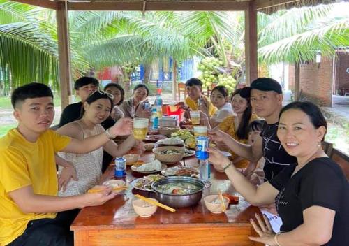 罗夷宝安日落海滩度假村的一群坐在桌子旁吃食物的人