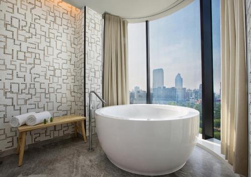 高雄高雄中央公园英迪格酒店的带浴缸的浴室和大窗户