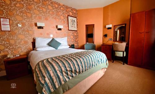 兰德林多德威尔斯大都会Spa酒店的配有一张床和一把椅子的酒店客房