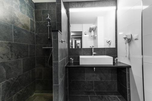 阿尔梅勒阿尔梅勒酒店的黑白浴室设有水槽和镜子