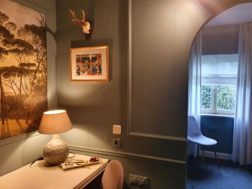 KlimmenBoutique Hotel Villa de Proosdij的客房设有带台灯和窗户的书桌。