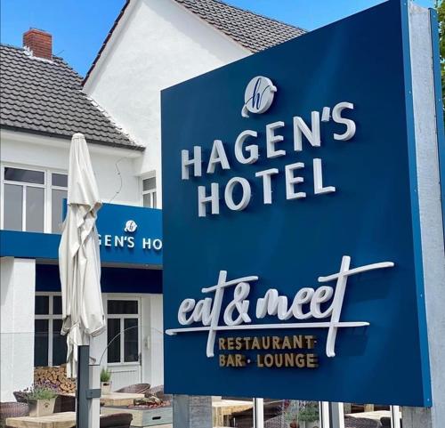 哈伦Hagen`s Hotel "eat & meet" Restaurant Bar Lounge的酒店前方的白色遮阳伞标志