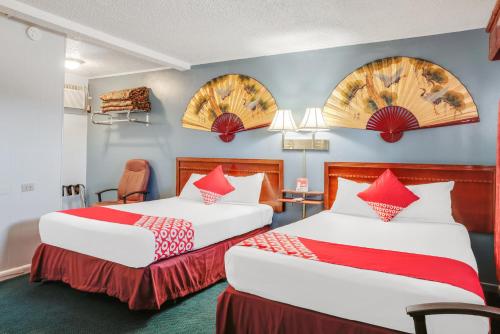 利柏提OYO Hotel Liberal, Kansas的两张位于酒店客房的床铺,配有红色枕头