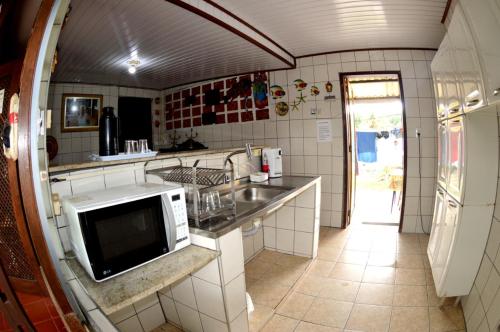 伯迪亚哥Pousada da Geisa的厨房配有水槽和微波炉