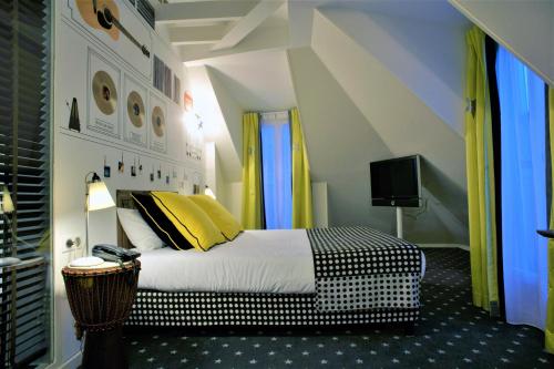 巴黎金三角酒店的一间卧室配有一张带黄色和黑色枕头的床