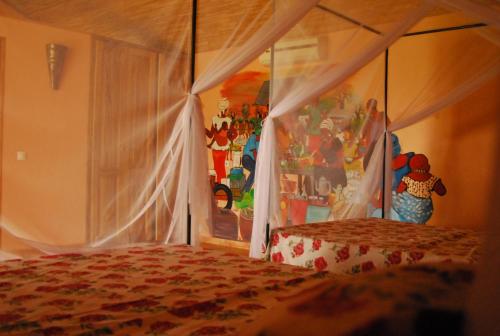 Sinndia猴面包树日光酒店的一间卧室配有一张带天蓬的床