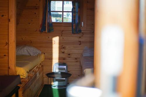 Yvoir勒博米尔鲁斯迪克露营地的小木屋内带两张床的小房间