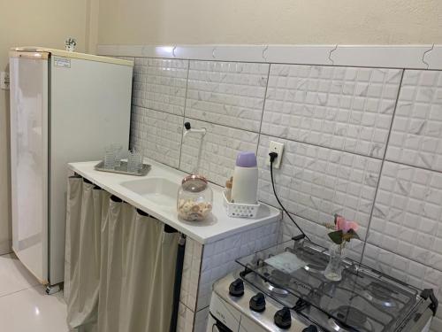 塞蒂拉瓜斯Kitnet - Apart Hotel 3的一间带水槽和炉灶的小厨房