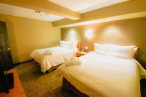 波蒂奇拉普雷里Canad Inns Destination Centre Portage la Prairie的酒店客房,配有两张带白色床单的床