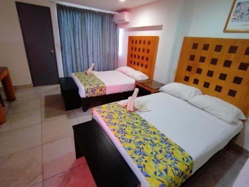 韦拉克鲁斯夏米酒店的一间酒店客房,房间内设有两张床