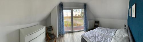 LoissinBoddenhus Loissin的一间卧室设有一张床和一个大窗户