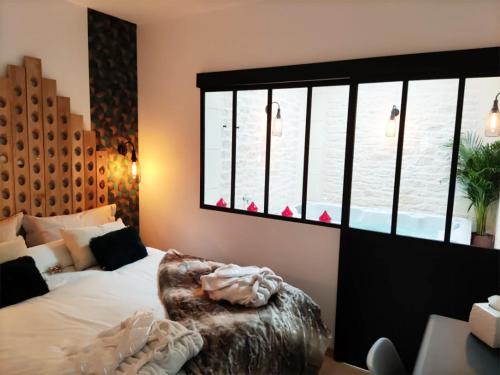 埃佩尔奈L'Atelier - Gîte & Spa的一间卧室设有一张床和一个大窗户
