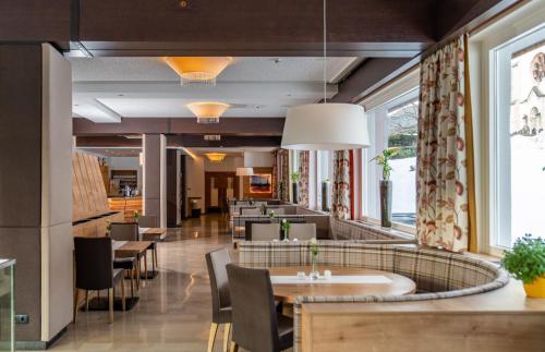 拉姆绍达赫斯坦Aktivhotel Pehab的餐厅设有桌椅和大窗户。