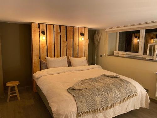 绍德方丹Le Retour aux Sources - Chambre d'Hôte chaleureuse et conviviale的一间卧室配有一张大床和木制床头板