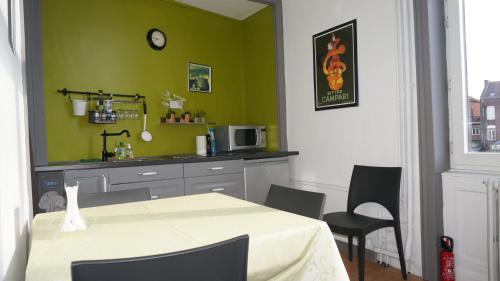 鲁贝阿布里杜帕桑特酒店的厨房配有桌椅和绿色的墙壁