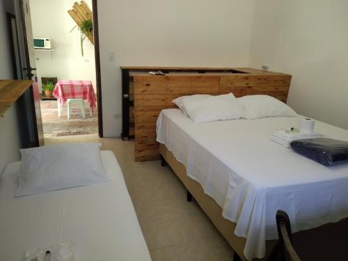 伊瓜佩Pousada Iguape的一间卧室配有两张床和一张桌子及椅子