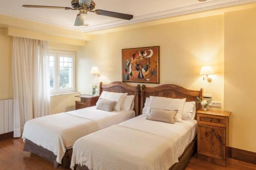 圣塞瓦斯蒂安拉格瑞酒店的一间卧室配有两张床和吊扇
