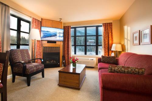 惠斯勒Sundial Hotel的客厅设有红色的沙发和壁炉