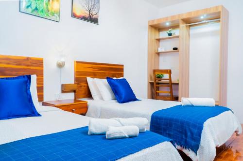 波托维耶霍Hotel Boutique Platanal的蓝色和白色的客房内的两张床