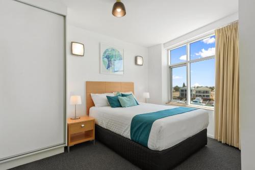 沃拉鲁Wallaroo Marina Sea Vu Apartment的一间卧室设有一张床和一个大窗户