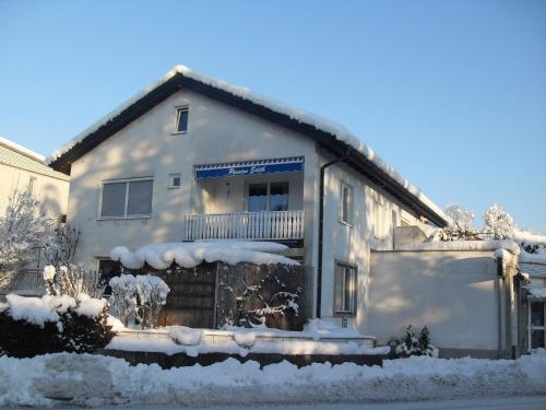 布雷根茨Haus Edith Privathaus mit Gästezimmern的白色房子的一侧有雪