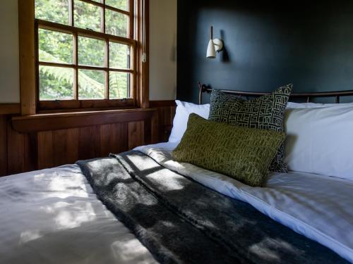 MeanderCedar Cottage Meander的卧室里一张带绿色枕头的床