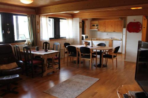 罗恩Bergfosshytta 1 sør的一间带桌椅的用餐室和一间厨房