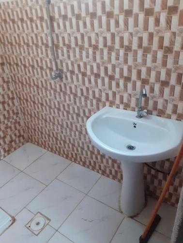 穆哈伊犁Alkithri Apartments for Singls的浴室设有白色水槽和瓷砖墙