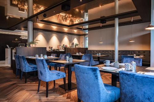 思科纳Prunner Luxury Suites - Adults Only的一间配备有蓝色椅子和桌子的用餐室