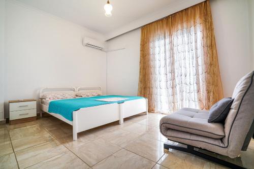 内亚卡瓦里Dimitra Beach Apartments - Nea Karvali Kavala的一间小卧室,配有一张床和一把椅子