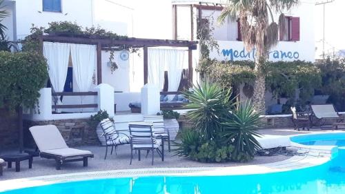 伊奥斯乔拉地中海酒店的一个带椅子的庭院和一个游泳池