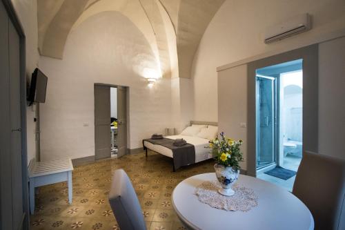 马蒂诺Le Finestre Su Porta Carrese - Luxury Rooms & Suites的客厅配有床和桌子
