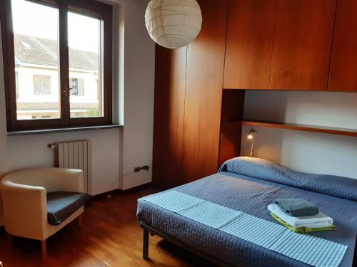 巴斯基里奥B&B Il Glicine di Basiglio的卧室配有床、椅子和窗户。