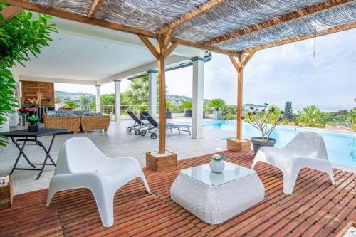 波尔蒂乔Villa individuelle avec piscine privée chauffée proche commerces et plage的一个带白色椅子和游泳池的庭院