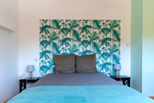 班纳萨克迪云洁腊特瑞住宿加早餐旅馆的一间卧室配有蓝色的床,拥有蓝色和绿色的壁纸