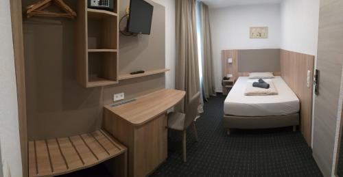 沃尔姆斯Hotel Kriemhilde的小房间设有一张床、一张桌子和一台电视机