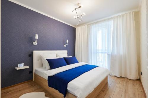 明斯克PaulMarie Apartments on Mayakovskogo 35的卧室配有蓝色和白色的床和窗户。