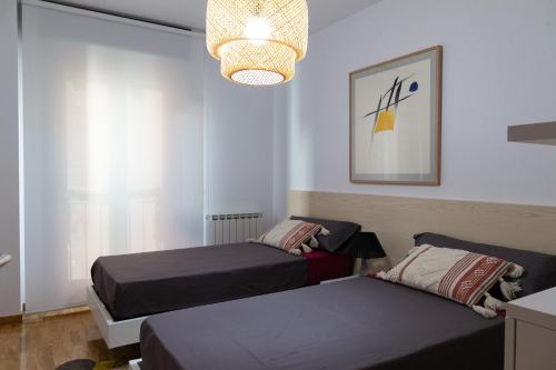 萨莫拉DONCELLAS的一间卧室配有两张床和吊灯。