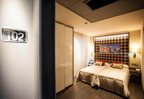 萨拉曼卡巴塞罗那旅馆的酒店客房,设有一张床,墙上有标志