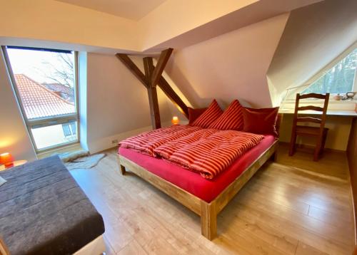 莱比锡Leipziger Logis的一间卧室配有一张红色棉被的床