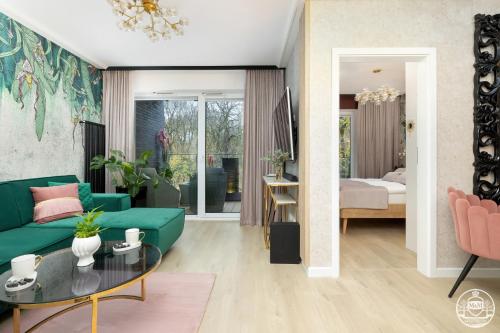 科沃布热格Nadmorskie Tarasy - Apartments M&M的客厅配有绿色沙发和桌子