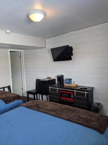 熔岩温泉村Lost Trail的一间卧室配有一张床,墙上配有电视
