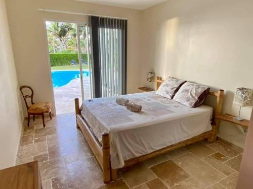 Ravine des CabrisVilla BELLE VUE, CHAMBRE BAMBOUS的一间卧室设有一张床,享有游泳池的景色