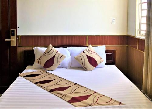 芹苴Hong Dao 2 Hotel的一张带白色床单和枕头的床