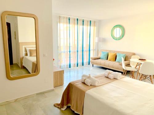 贝纳尔马德纳Apartamento Marina Suite的一间卧室配有一张床、镜子和一张沙发