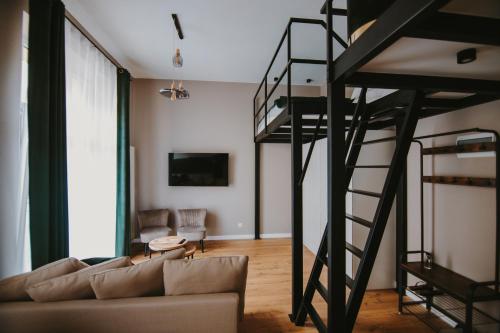 罗兹Apartament Green - Piotrkowska 37的客厅配有高架床和沙发