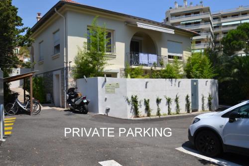 戛纳Villa Etoile Cannes的停在大楼前停车场的汽车