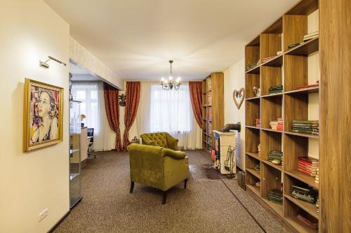 克莱佩达Art Hotel Bohema, Klaipėda的客厅配有绿色椅子和书架