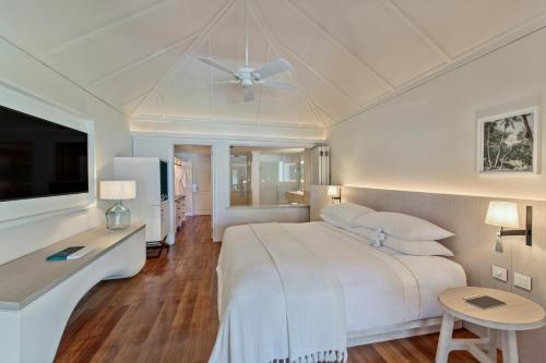 勒莫尔尼LUX* Le Morne Resort的白色卧室配有床和吊扇